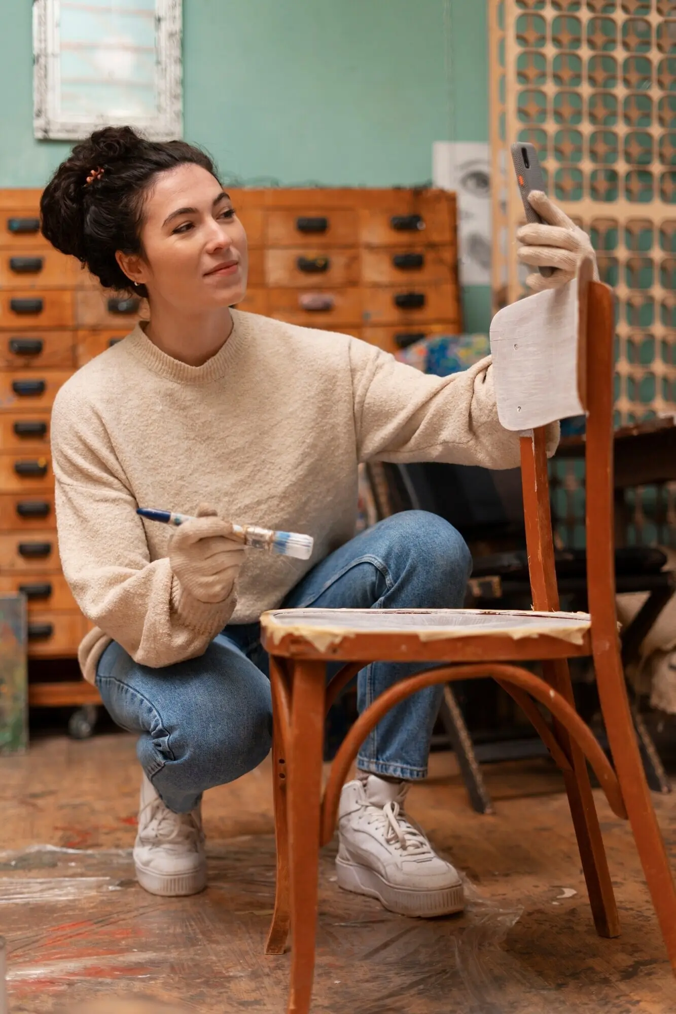 Full-body shot of a woman restoring wooden furniture